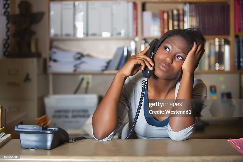 USA, Texas, Young woman having conversation in office