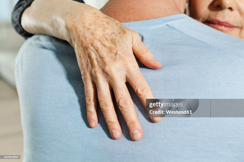 Germany, Berlin, Senior couple embracing, close up