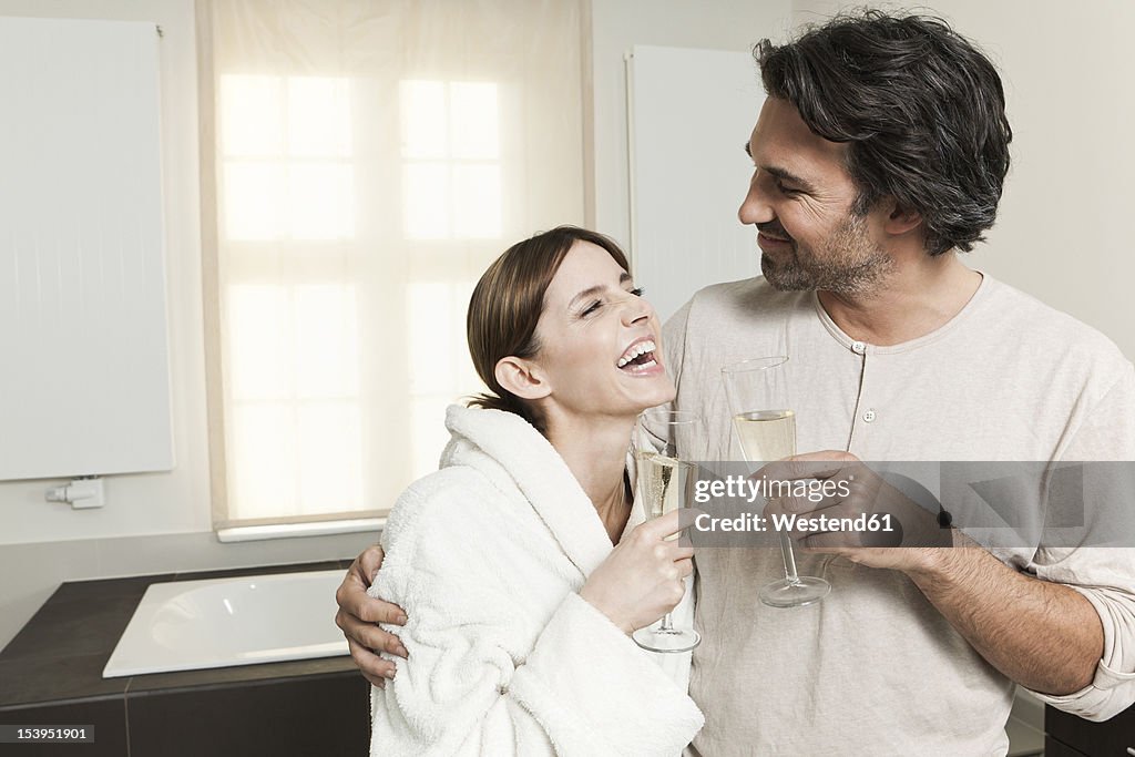 Germany, Berlin, Mature couple in bathroom with sparkling wine