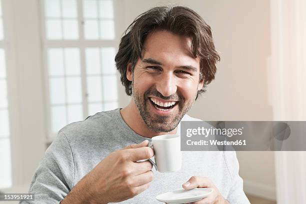 germany, berlin, mature man with coffee cup, smiling, portrait - coffee indulgence stock pictures, royalty-free photos & images