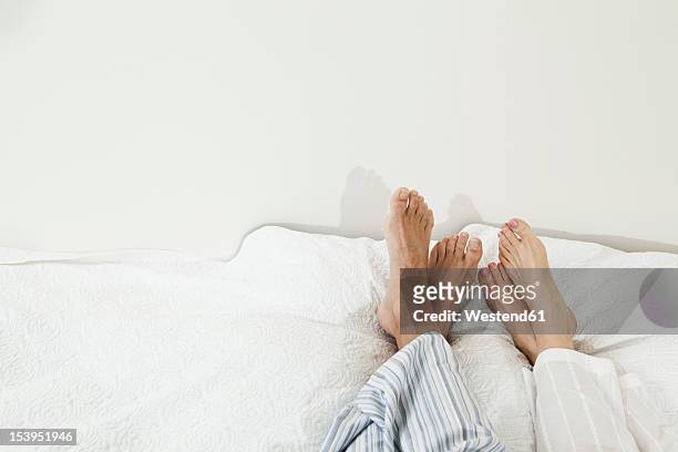 germany, berlin, mature couple relaxing - feet in bed stock pictures, royalty-free photos & images