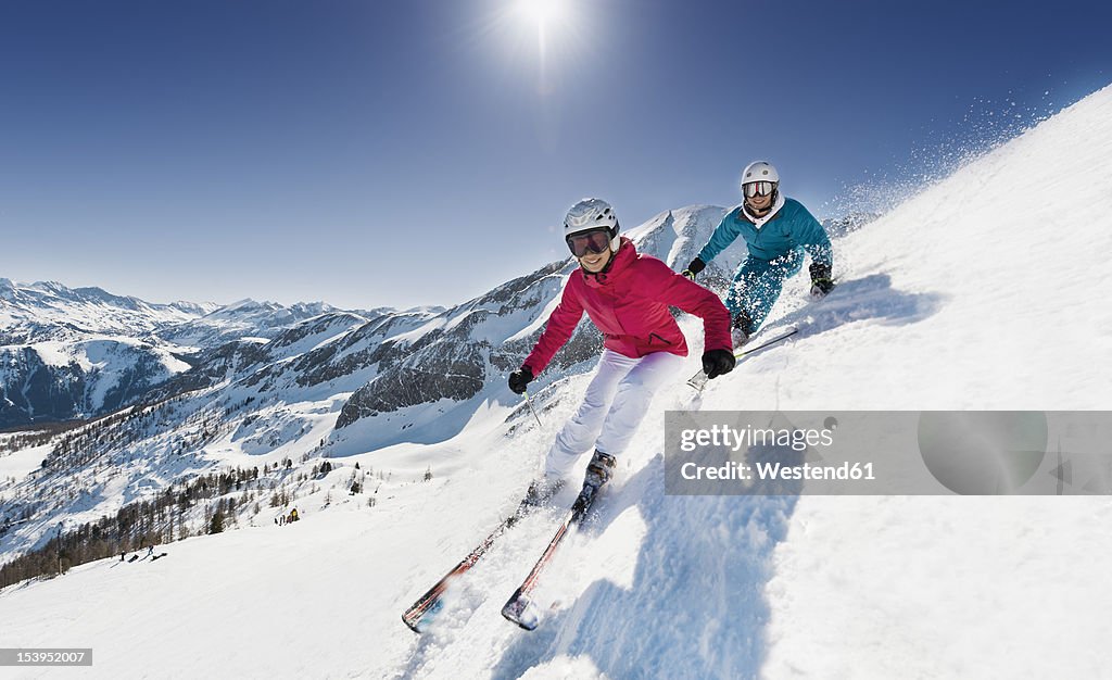 Austria, Salzburg, Young couple skiing on mountain