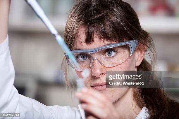 germany, bavaria, munich, scientist with pipette and test tube in laboratory - vetenskapskvinna bildbanksfoton och bilder