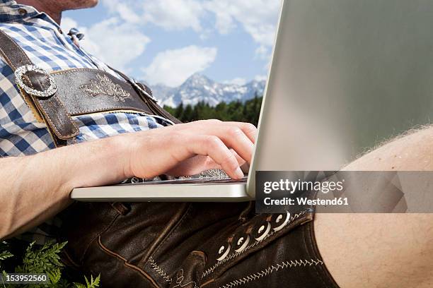 germany, bavaria, mid adult man using laptop - bayern muster stock-fotos und bilder