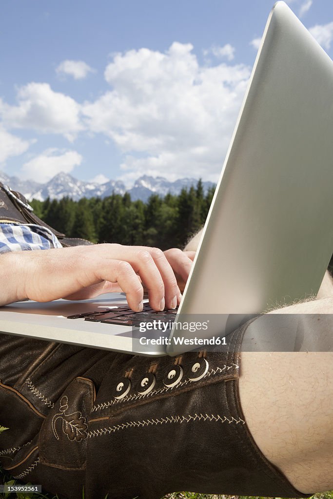 Germany, Bavaria, Mid adult man using laptop