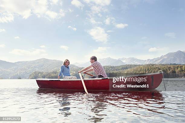 germany, bavaria, couple in rowing boat, smiling - bateau à rames photos et images de collection