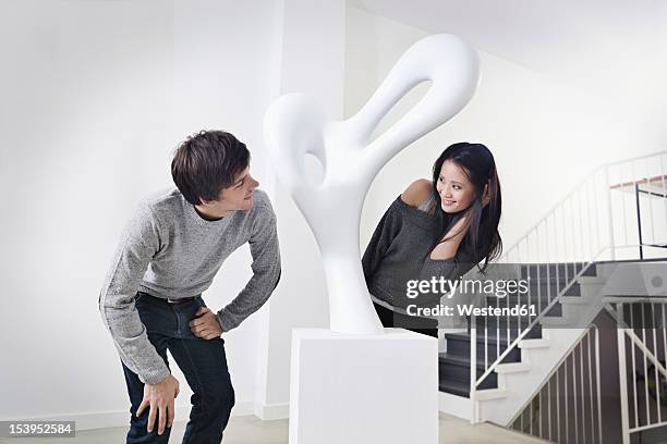 germany, cologne, young couple standing in art gallery, smiling - looking at art stock pictures, royalty-free photos & images