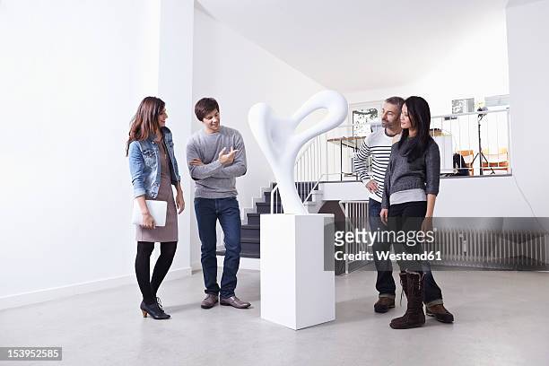 germany, cologne, man and woman standing in art gallery, smiling - skulptur kunstwerk stock-fotos und bilder