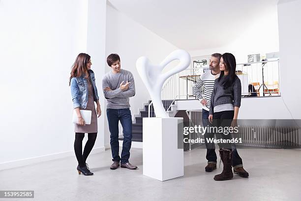 germany, cologne, man and woman standing in art gallery, smiling - art gallery people fotografías e imágenes de stock