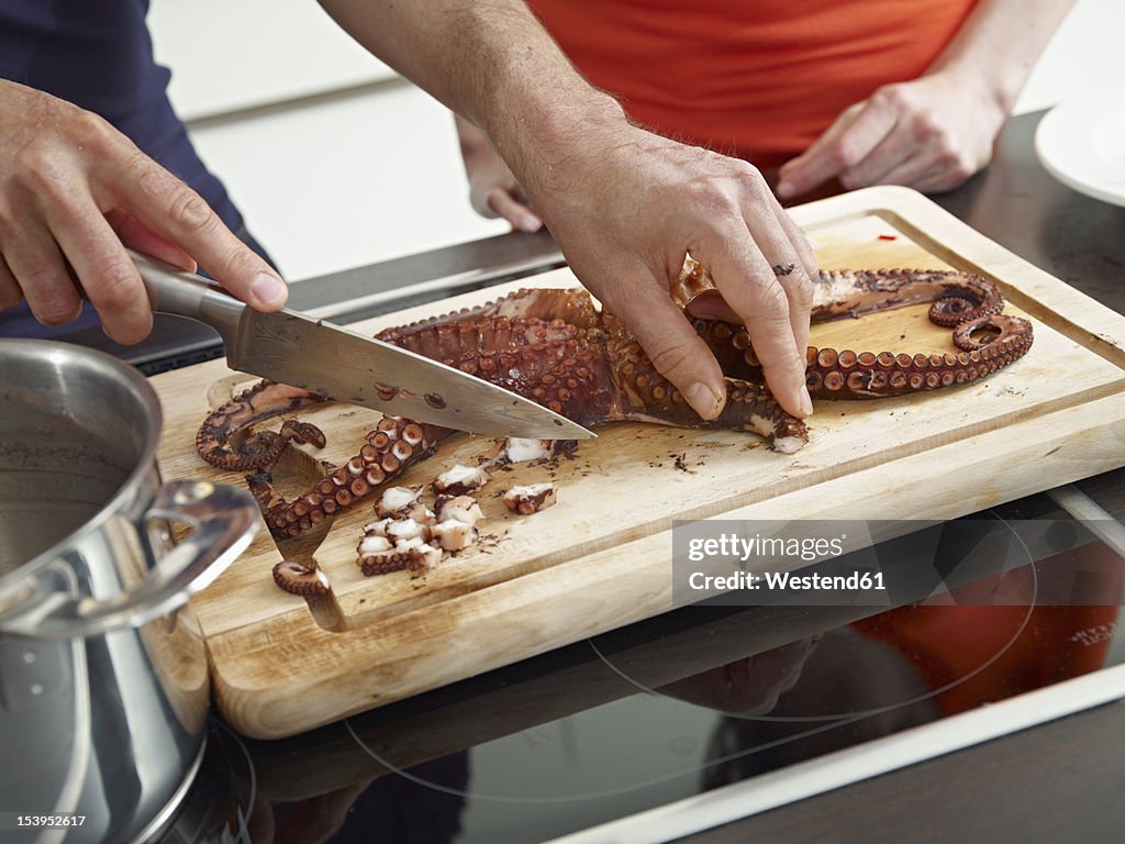 Germany, Cologne, Man and woman cooking together in kitchen