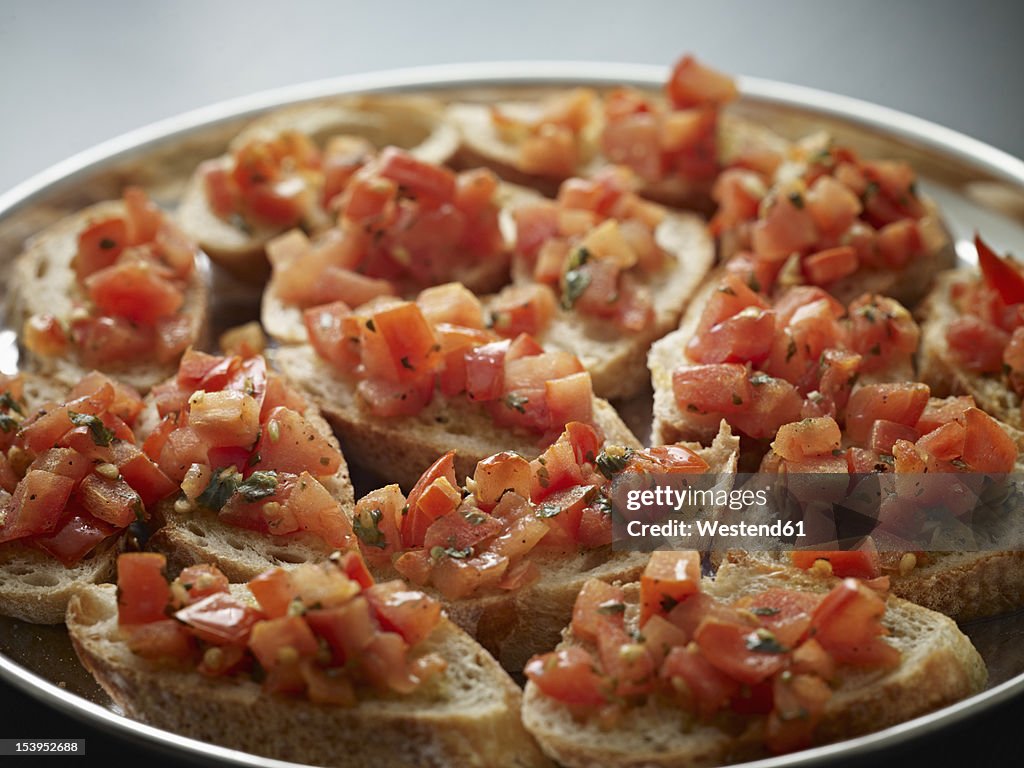 Germany, Cologne, Bread with tomato and basil in plate, close up