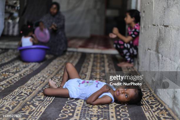 Palestinian girl rests in her house during a heat wave and lengthy power cuts in a slum on the outskirts of the Beit Lahia in the northen Gaza Strip,...