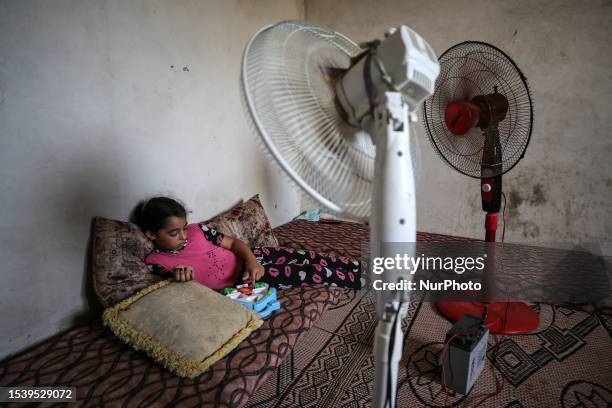 Palestinian girl rests in her house during a heat wave and lengthy power cuts in a slum on the outskirts of the Beit Lahia in the northen Gaza Strip,...