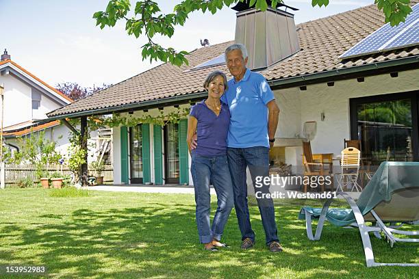 germany, bavaria, senior couple standing in yard, smiling - bavarian man in front of house stock-fotos und bilder