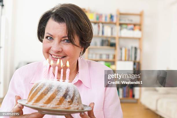 germany, leipzig, senior woman holding birthday cake - bundtkaka bildbanksfoton och bilder