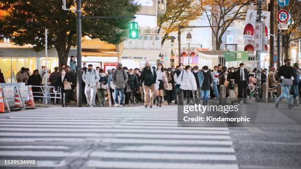 crowd of japanese, asian people, tourist traveler walk cross road at shibuya scramble crossing in tokyo at night. japan tourist attraction, travel landmark, asia transportation city life concept - road signal stock pictures, royalty-free photos & images