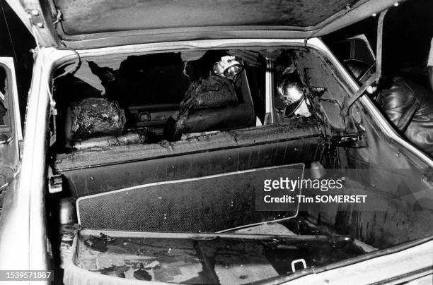 Un sapeur-pompier fouille une voiture brûlée après les émeutes à Vénissieux le 8 septembre 1981.