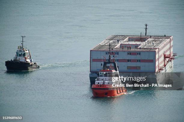 Tug boat Mercia pulls the Bibby Stockholm accommodation barge into Portland in Dorset where it is due to house migrants after travelling from dry...