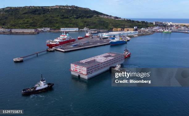 Tug boats bring the Bibby Stockholm asylum seeker accommodation barge to its moorings at Portland Port in Portland, UK, on Tuesday, July 18, 2023....