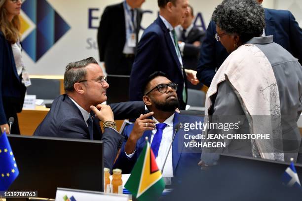 Luxembourg's Prime Minister Xavier Bettel speaks with Barbados Prime Minister Mia Mottley and Guyana's President Irfaan Ali before the plenary...