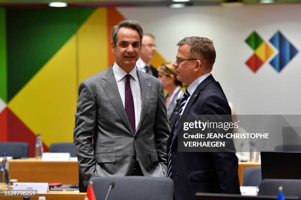 Greece's Prime Minister Kyriakos Mitsotakis speaks with Finland's Prime Minister Petteri Orpo before the plenary session of a summit of the European...