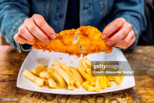 man eating fish and chips, close-up, london, uk - fish chips stockfoto's en -beelden