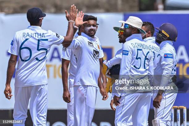 Sri Lanka's Ramesh Mendis celebrates with teammates after taking the wicket of Pakistan's Noman Ali during the third day play of the first cricket...