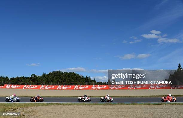 Moto3-class Kalex KTM rider Luca Amato of Germany leads FTR Honda rider Louis Rossi of France , Honda rider Toni Finsterbusch of Germany , KTM rider...