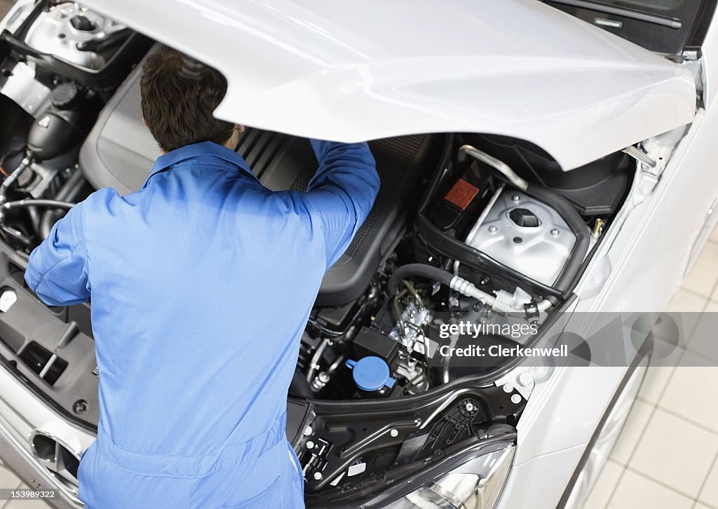 Mechanic working on engine in auto repair shop