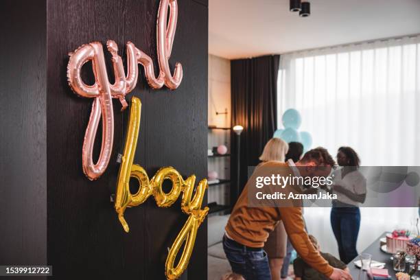 close up of the balloons with the gender reveal party guests in the background - gender reveal stock pictures, royalty-free photos & images