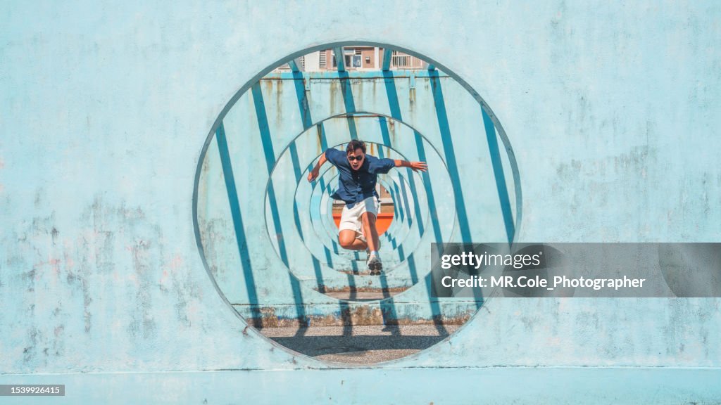 Asian man jumping out of circle