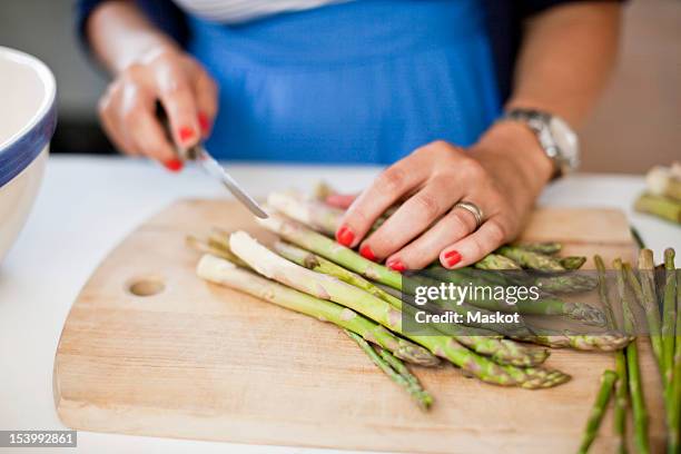 close-up of woman chopping asparagus on cutting board - asparagus stock pictures, royalty-free photos & images