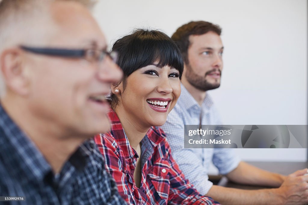 Businesswoman with colleagues smiling in office meeting