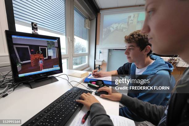 Koerbele high school students use a computer software recreating an imaginary city, on October 10 in Selestat, eastern France. AFP PHOTO/FREDERICK...