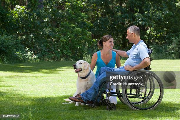 man with spinal cord injury in wheelchair with his wife and dog - duxbury, massachusetts stock pictures, royalty-free photos & images