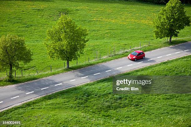 auto rossa sulla strada di campagna, primavera, veduta aerea - strada di campagna foto e immagini stock
