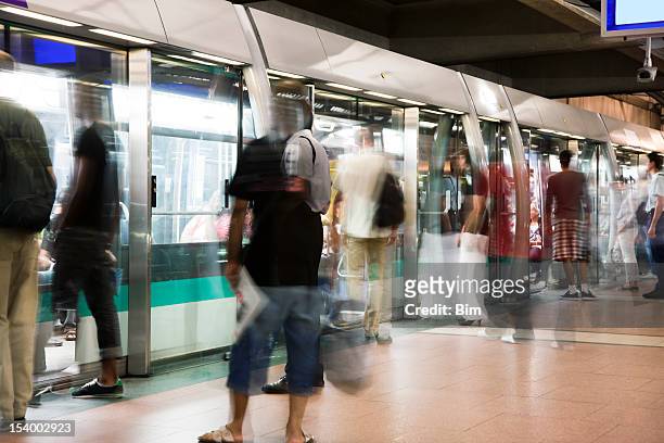 blurred people getting into subway train during paris rush hour - betreden stockfoto's en -beelden