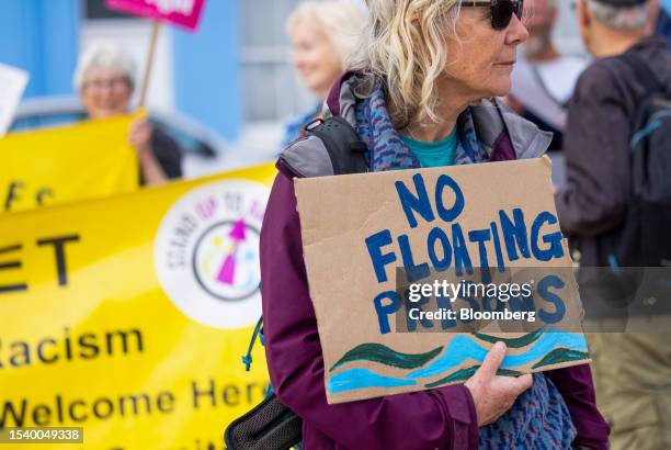Protestor holds a placard which reads "No Floating Prisons" at Portland Port, following the arrival of the Bibby Stockholm asylum seeker...