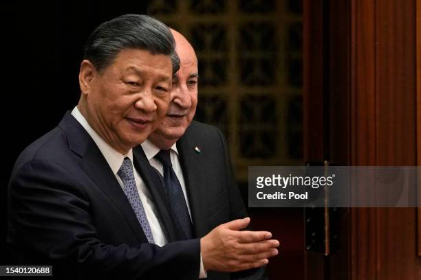 Chinese President Xi Jinping shows the way for Algerian President Abdelmadjid Tebboune as they arrive for a signing ceremony held at the Great Hall...