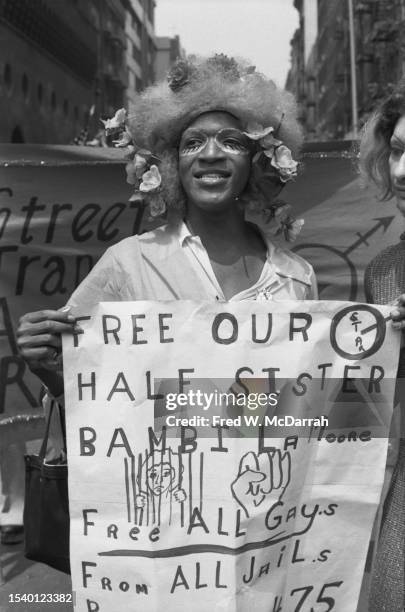 American gay liberation and transgender rights activist Marsha P Johnson poses with a sign during the fourth annual Gay Pride Day March , New York,...