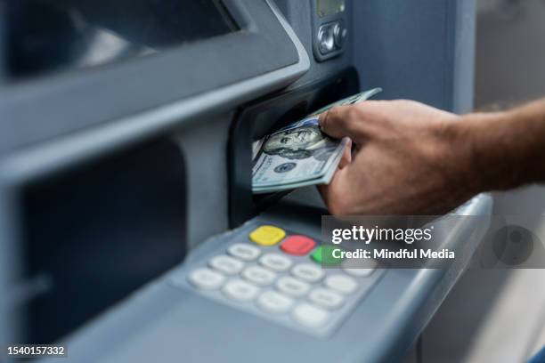 primo piano dell'uomo che deposita denaro sul bancomat - cash withdrawal foto e immagini stock