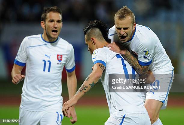 Slovakia's midfielder Marek Hamsik celebrates his goal with midfielder Marek Sapara and forward Marek Bakos during the FIFA 2014 World Cup qualifier...