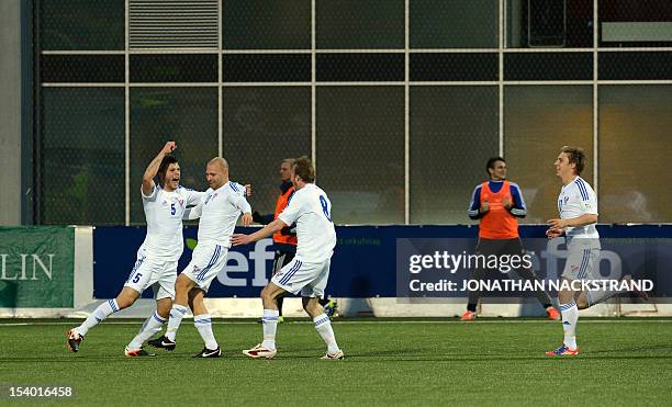 Faroe's defender Rogvi Baldvinsson celebrates with his teammates after he scored during the FIFA 2014 World Cup qualifier football match Faroe...