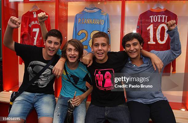 Fans pose next to an exhibition of football memorabilia during the UEFA Champions League Trophy Tour 2012/13 on October 12, 2012 in Naples, Italy.