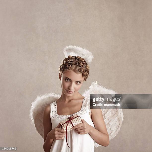 angel holding a wrapped gift - touched by an angel stockfoto's en -beelden