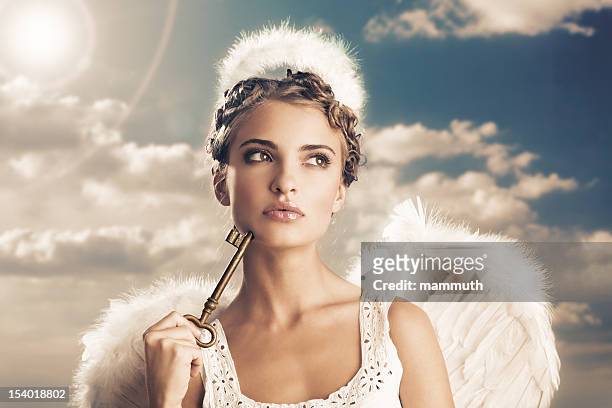 angel holding the key of heaven - angels stock pictures, royalty-free photos & images