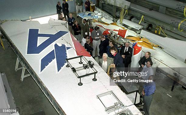 Marion Blakey, on ladder, head of the National Transportation Safety Board, and Sean O''Keefe, NASA Administrator, next to ladder, look over the tail...