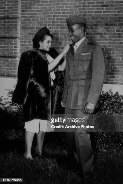 American military officer Frederick C Branch, the United States Marine Corps' first African-American officer, smiles as his wife, Peggy Branch, pins...