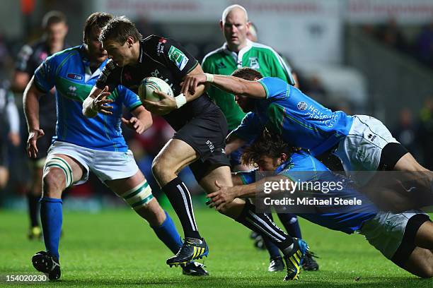 Dan Biggar of Ospreys is held up by Ignacio Fernandez-Rouyet and Fabio Semenzato of Benetton Rugby Treviso during the Heineken Cup Pool Two match...