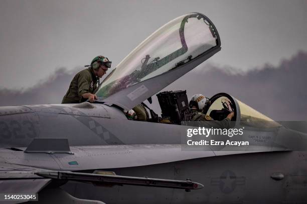 Marines prepare an F/A-18 Hornet fighter jet as they take part in the bi-annual Marine Aviation Support Activity 23 at the airport of a former US...